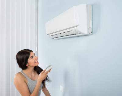 woman using remote to set heat pump